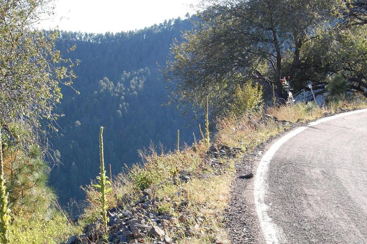The edge of the asphalt and a sharp dropoff to a deep canyon leave no room on the shoulder for a safety guardrail or a bike lane on this mountain road's curve.